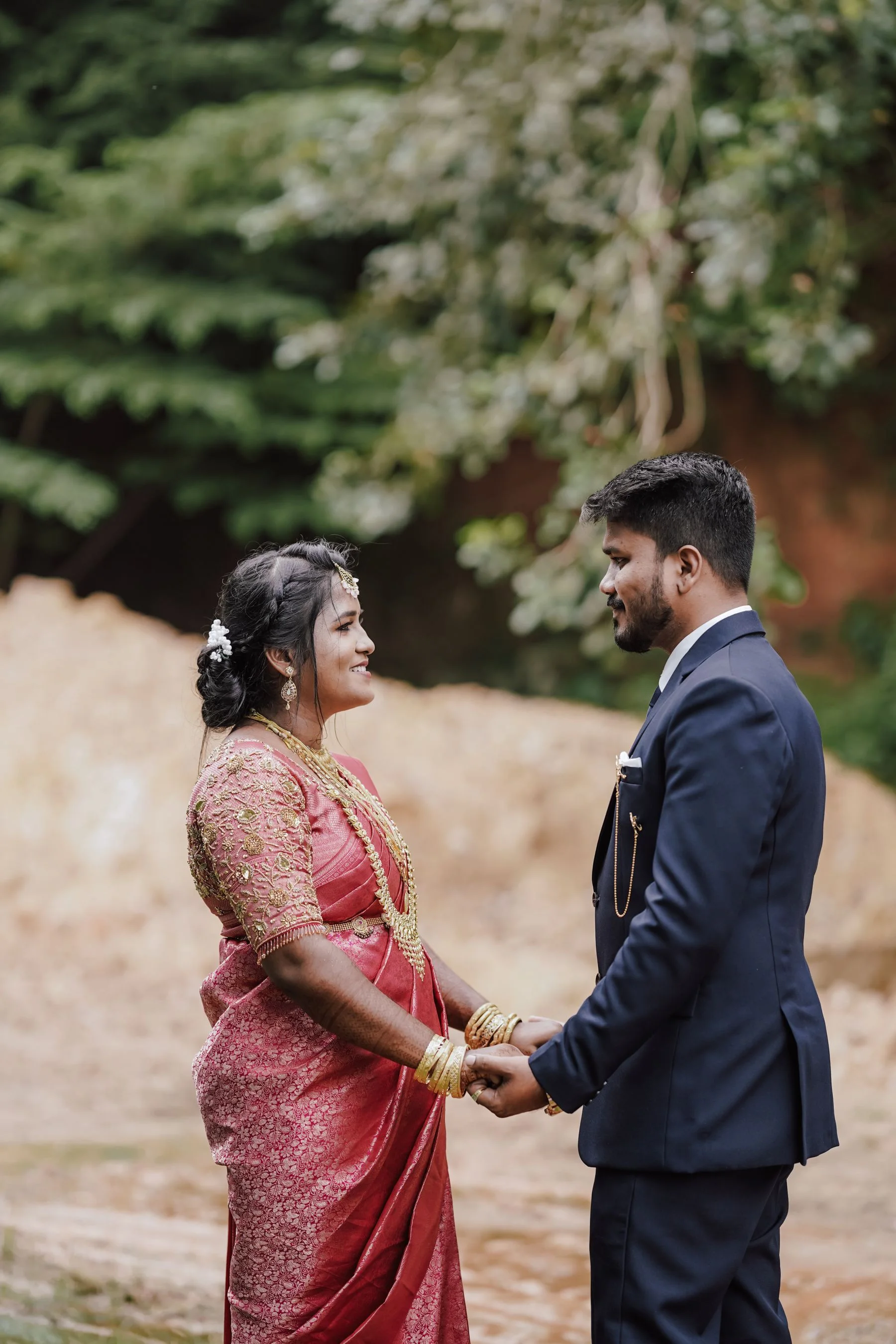 South Asian couple in traditional wedding attire outdoors
